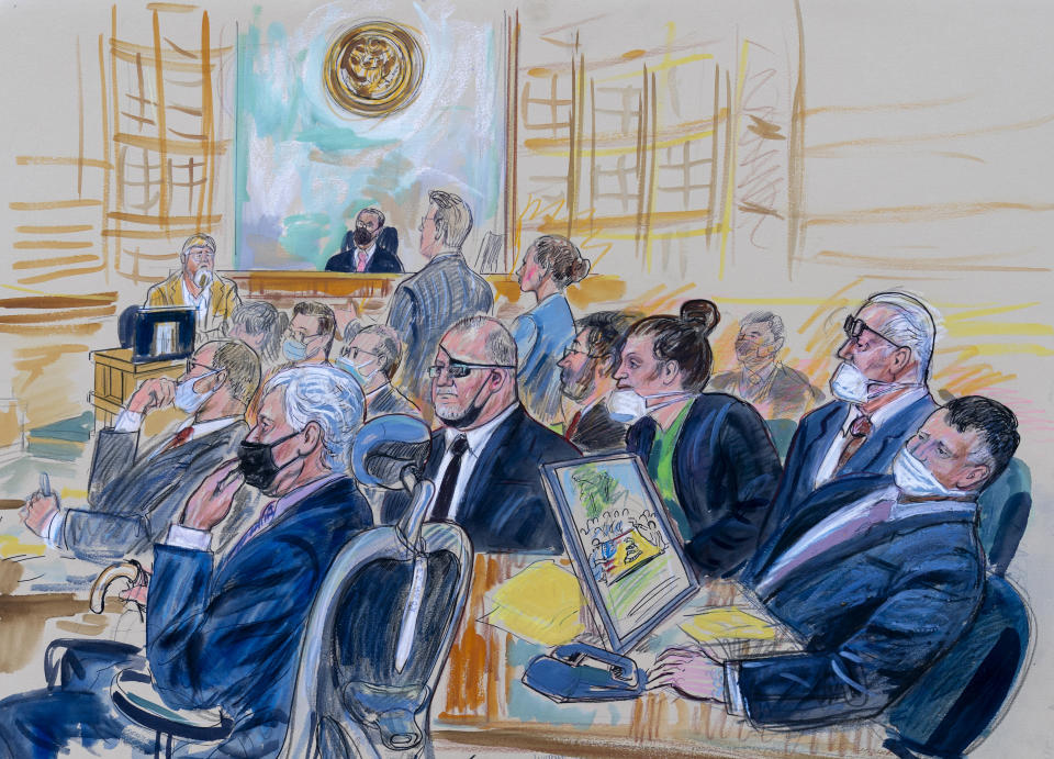 FILE - This artist sketch depicts the trial of Oath Keepers leader Stewart Rhodes and four others charged with seditious conspiracy in the Jan. 6, 2021, Capitol attack, in Washington, Oct. 6, 2022. Shown above are, witness John Zimmerman, who was part of the Oath Keepers' North Carolina Chapter, seated in the witness stand, defendant Thomas Caldwell, of Berryville, Va., seated front row left, Oath Keepers leader Stewart Rhodes, seated second left with an eye patch, defendant Jessica Watkins, of Woodstock, Ohio, seated third from right, Kelly Meggs, of Dunnellon, Fla., seated second from right, and defendant Kenneth Harrelson, of Titusville, Fla., seated at right. Assistant U.S. Attorney Kathryn Rakoczy is shown in blue standing at right before U.S. District Judge Amit Mehta. U.S. Army veterans Watkins and Harrelson are scheduled to be sentenced on Friday, May 26, 2023 (Dana Verkouteren via AP)