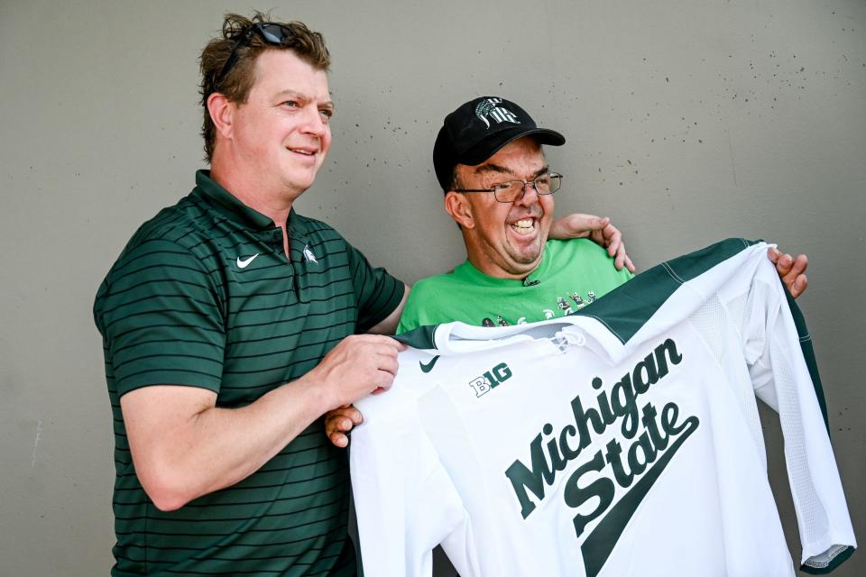 Michigan State hockey coach Adam Nightingale, left, poses for a photo with Dave Esch after presenting Esch with a jersey on Wednesday, July 20, 2022, at the Meijer in Grand Ledge. Esch was celebrated for returning his millionth shopping cart as an employee of the store.