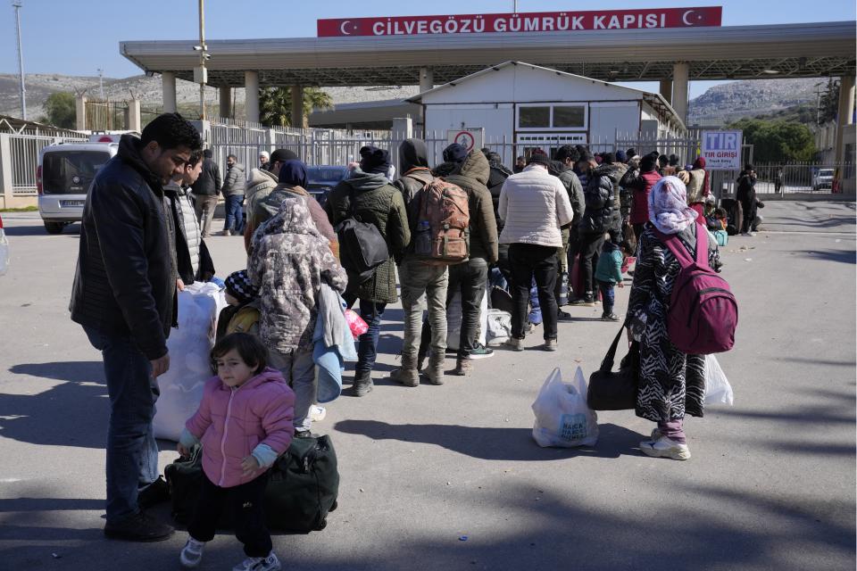 Syrians stand in a queue as they wait to return to their country from the Turkish crossing point of Cilvegozu, in Reyhanli, southeastern Turkey, Thursday, Feb. 9, 2023. Rescuers pulled more survivors from beneath the rubble of collapsed buildings Thursday, but hopes were starting to fade of finding many more people alive more than three days after a catastrophic earthquake and series of aftershocks hit Turkey and Syria. (AP Photo/Hussein Malla)