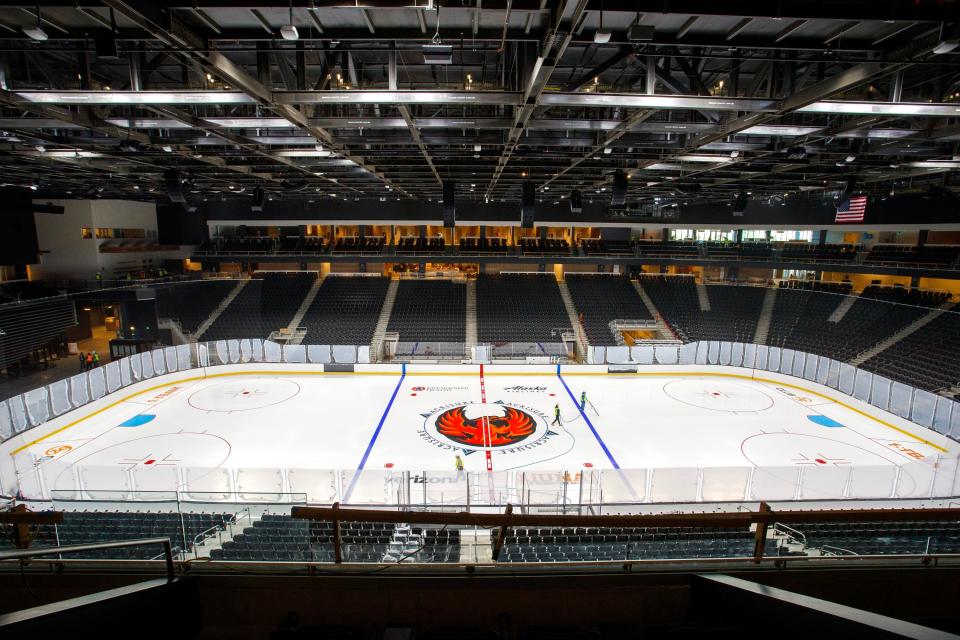 Mid American Rink Services workers spray water and thin layers of paint to make the ice and logos inside Acrisure Arena, the home of the Coachella Valley Firebirds, hockey rink in Thousand Palms, Calif., on Wednesday, Dec. 7, 2022. 