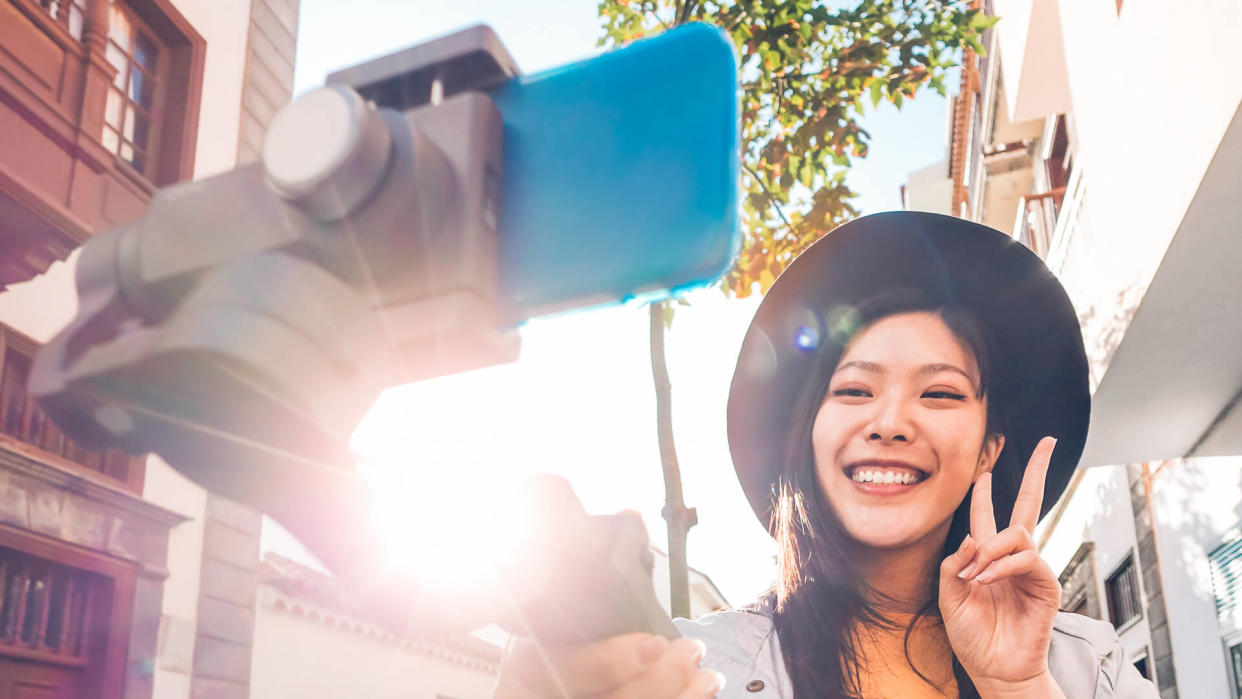 girl using selfie stick recording a video