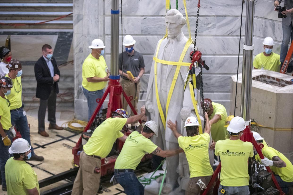 Workers prepare to remove the Jefferson Davis statue from the Kentucky State Capitol in Frankfort, Ky. on Saturday, June 13, 2020. A Kentucky commission voted to take down a statue of Confederate President Jefferson Davis from the state Capitol. The panel supported a push from the governor as the country faces protests against police brutality following the deaths of African Americans in encounters with police.