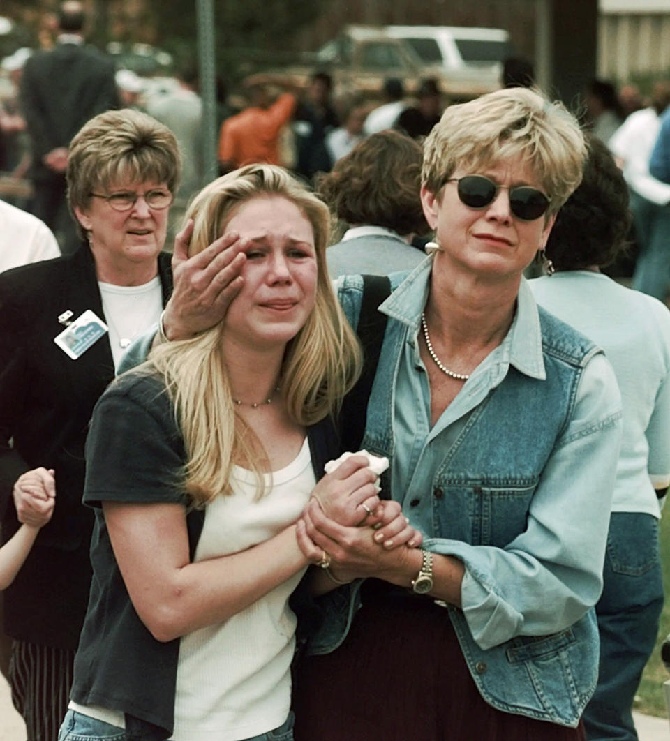 FILE - Fran Allison, right, comforts her daughter, Brooke, after they were reunited following a shooting at Columbine High School in Littleton, Colo., April 20, 1999. Twenty-five years later, The Associated Press is republishing this story about the attack, the product of reporting from more than a dozen AP journalists who conducted interviews in the hours after it happened. The article first appeared on April 22, 1999. (AP Photo/Ed Andrieski, File)