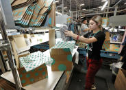 In this Tuesday, March 12, 2019, photo Yakaranday Arce packs sold clothing for shipment at the ThredUp sorting facility in Phoenix. Charitable organizations like Goodwill have cited how Marie Kondo’s popular Netflix series, “Tidying up with Marie Kondo” has led to a surge of donations. And sites like OfferUp and thredUP also note an uptick in the number of items being sent to them for sale. (AP Photo/Matt York)