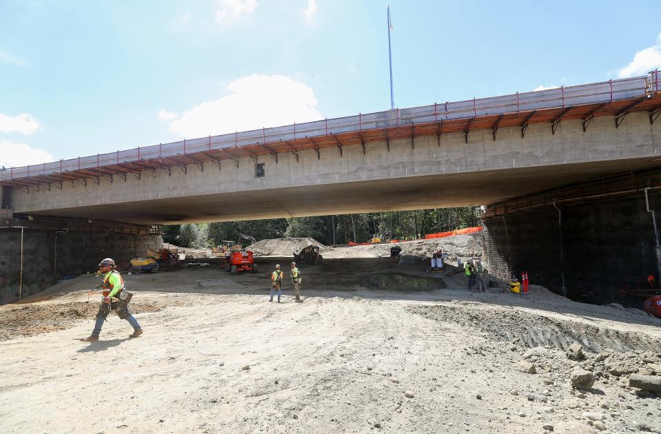 Construction crew members move about beneath the Highway 3 Chico Creek bridge on Tuesday, Aug. 8, 2023.