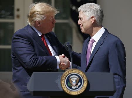 Judge Neil Gorsuch is congratulated by U.S. President Donald J. Trump after being sworn in as an associate justice of the Supreme Court in the Rose Garden of the White House in Washington, U.S., April 10, 2017. REUTERS/Joshua Roberts