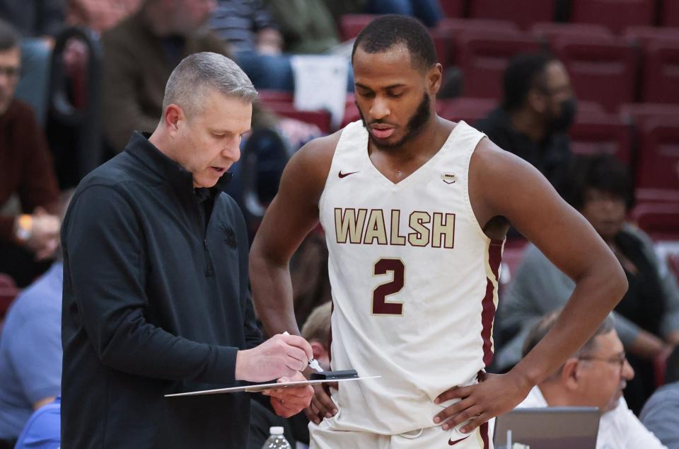 Walsh coach Jeff Young draws up a play as Milan Square looks on during a G-MAC Tournament semifinal against Findlay on March 4, 2022.