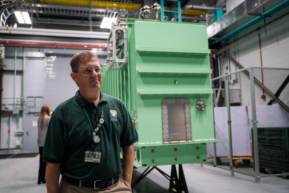 Zach Constan, outreach coordinator for FRIB, stands near a cryomodule inside the Facility for Rare Isotope Beams (FRIB) at Michigan State University in East Lansing on Tuesday, Aug. 1, 2023.