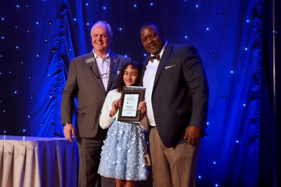 Andy Marshall, President and CEO of FirstBank Southwest, presents Tremaine Brown, right, along with his daughter Shilah the Amarillo Globe-News 2023 Man of the Year award at a ceremony held at the Amarillo Civic Center on Thursday night.