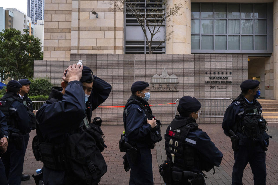 Police officers patrol outside the West Kowloon Magistrates' Courts, where activist publisher Jimmy Lai's trial takes place, in Hong Kong, Tuesday, Dec. 19, 2023. The national security trial of Hong Kong's most famous activist publisher Jimmy Lai entered its second day, with judges expected to rule on his lawyer's bid to throw out a sedition charge that has been increasingly used to target dissidents under Beijing's crackdown on Friday. (AP Photo/Louise Delmotte)