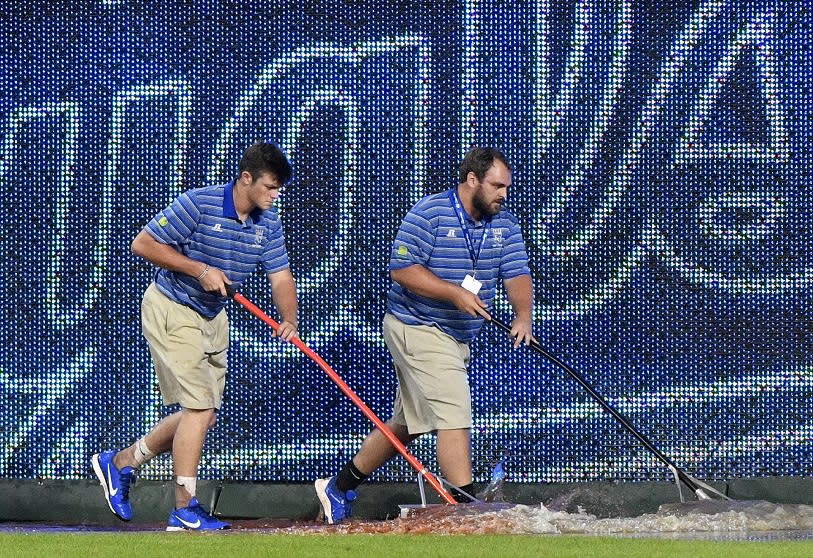 Members of the Royals’ grounds crew work to clear water from the field after water pipe broke at Kauffman Stadium. (Getty Images)