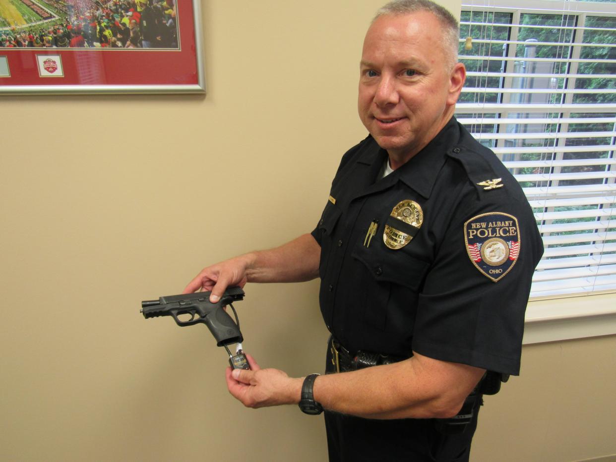 Greg Jones, chief of the New Albany Police Department, displays a gun-locking device. The department is handing out the gun locks upon request to anyone in the New Albany-Plain Local School District.