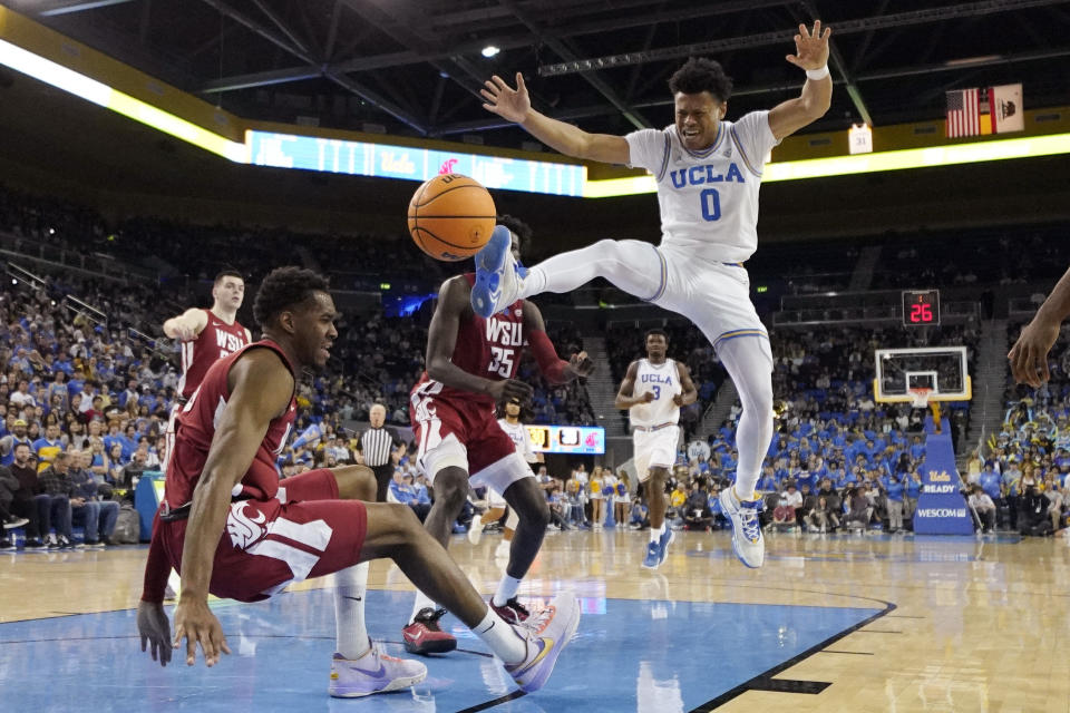 UCLA guard Jaylen Clark, right, loses control of the ball as Washington State guard Kymany Houinsou, left, falls during the second half of an NCAA college basketball game Saturday, Feb. 4, 2023, in Los Angeles. (AP Photo/Mark J. Terrill)