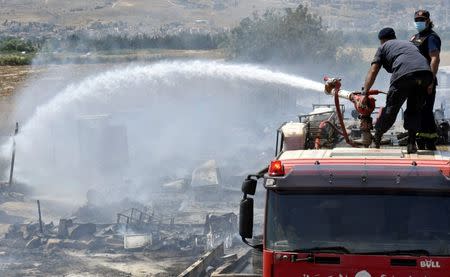 Civil defence members put out fire at a camp for Syrian refugees near the town of Qab Elias, in Lebanon's Bekaa Valley, July 2, 2017. REUTERS/Hassan Abdallah