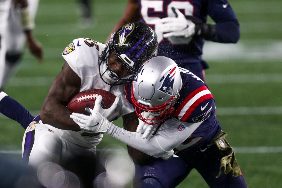 New England Patriots safety Devin McCourty (32) tackles Baltimore Ravens running back Gus Edwards (35) during the first half at Gillette Stadium on Nov. 15.