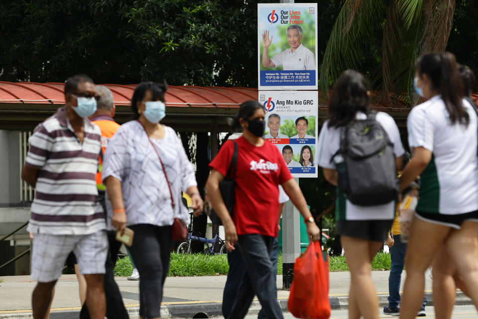 SINGAPORE - JUNE 30:  People walk past a People's Action Party poster along the street on June 30, 2020 in Singapore. Singapore will go to the polls on July 10 as the ruling party, People's Action Party seeks a fresh mandate amid the coronavirus (COVID-19) pandemic. As of June 29, the total number of COVID-19 cases in the country stands at 43,361.  (Photo by Suhaimi Abdullah/Getty Images)