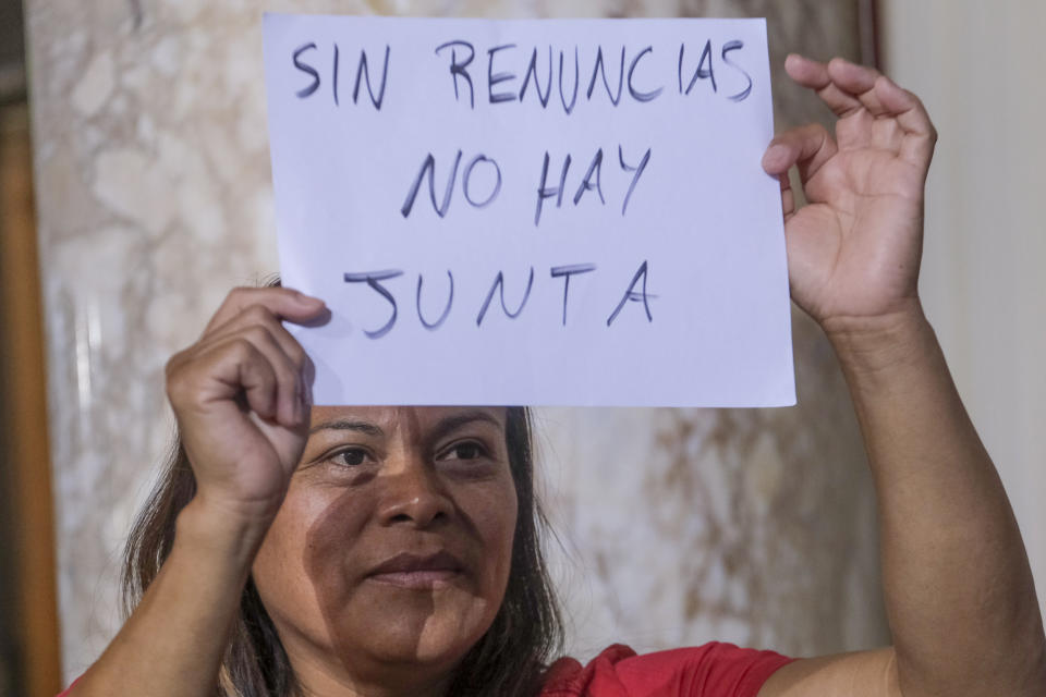 Ofelia Platon, from Oaxaca, holding a sign, protests before the cancellation of the Los Angeles City Council meeting Wednesday, Oct. 12, 2022 in Los Angeles. (AP Photo/Ringo H.W. Chiu)