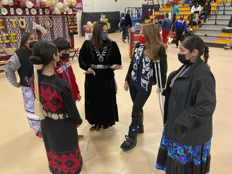 This Feb. 17, 2023 image shows school board member Paulene Abeyta, center, talking with U.S. Rep. Melanie Stansbury of New Mexico and others in the Navajo community of To'Hajiilee, New Mexico. To'Hajiilee Community School is just one of dozens funded by the U.S. Bureau of Indian Education that are in desperate need of repair or replacement. The school has secured more than $90 million in federal funding for a new campus. (AP Photo/Susan Montoya Bryan)