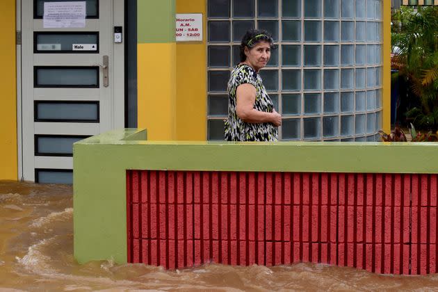 A woman stands outside her flooded house Monday in Salinas, Puerto Rico. (Photo: JOSE RODRIGUEZ via Getty Images)