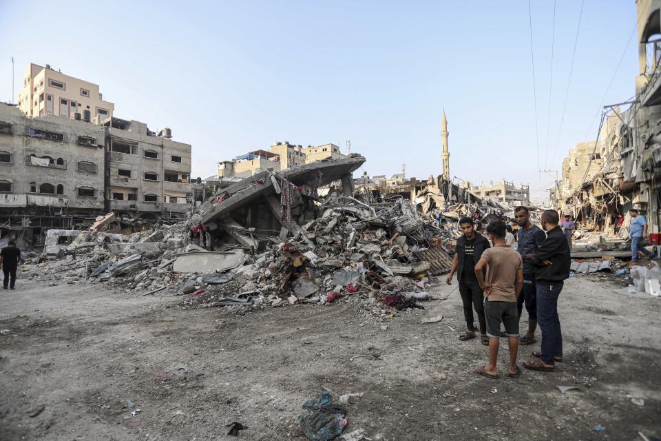 Palestinos inspeccionan los restos de edificios destruidos provocados por los ataques aéreos israelíes en Ciudad de Gaza, el sábado 28 de octubre de 2023. (AP Foto/Abed Khaled)