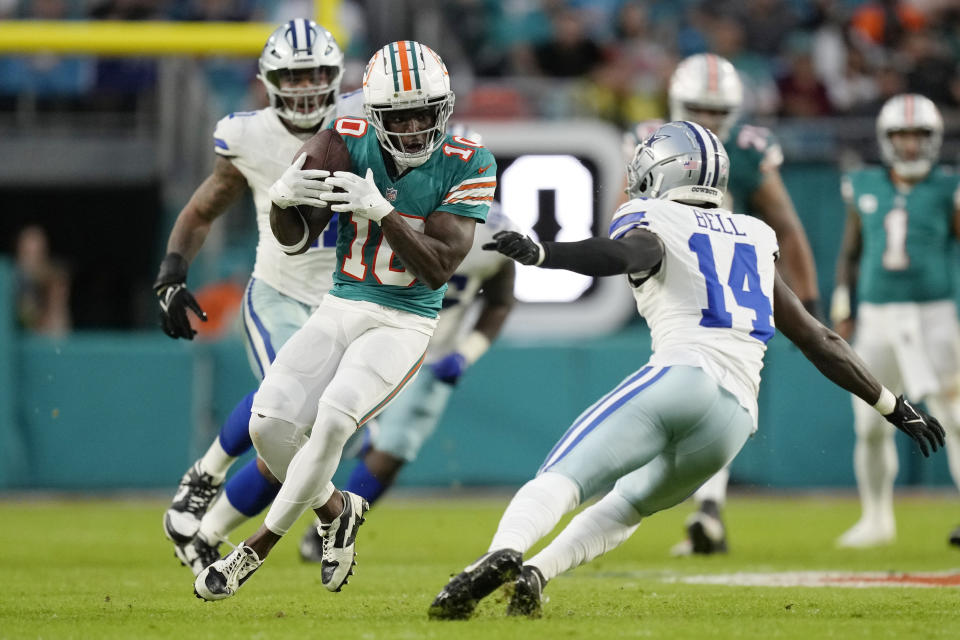 Miami Dolphins wide receiver Tyreek Hill (10) runs with the football as Dallas Cowboys safety Markquese Bell (14) defends during the first half of an NFL football game, Sunday, Dec. 24, 2023, in Miami Gardens, Fla. (AP Photo/Rebecca Blackwell)