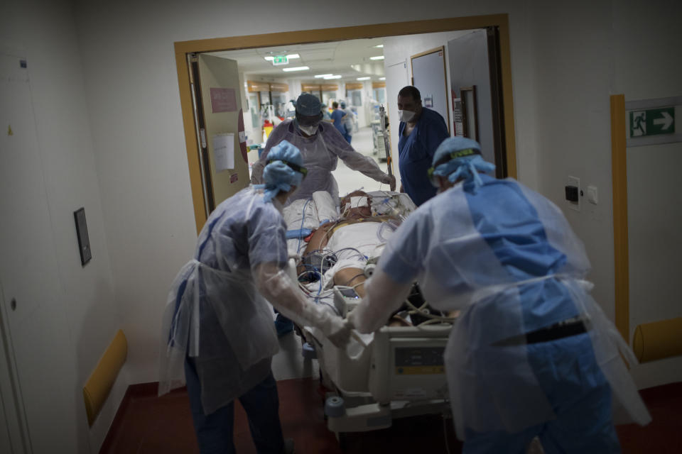 A 60-year-old COVID-19 patient is transferred to the main ICU at the La Timone hospital in Marseille, southern France, from a makeshift wing which could not support both the dialysis and respirator machines necessary for his worsening condition on Thursday, Nov. 12, 2020. France is more than two weeks into its second coronavirus lockdown, and intensive care wards have been over 95% capacity for more than 10 days now. Marseille has been submerged with coronavirus cases since September. The port city, on France's Mediterranean coast, was spared the worst of the virus last spring only to be hit with a vengeance as the summer vacation wound down. (AP Photo/Daniel Cole)