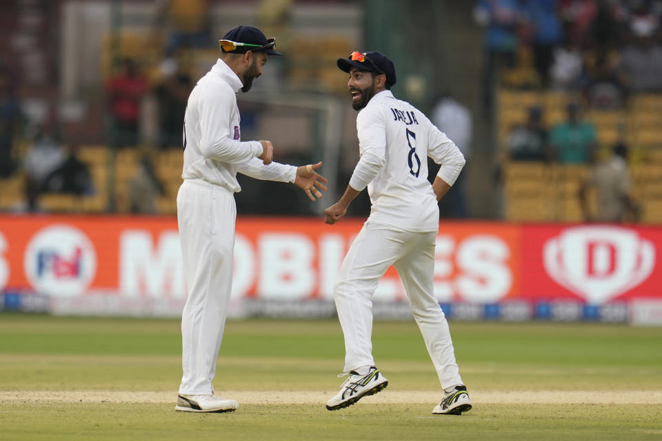 India's Virat Kohli, left, and Ravindra Jadeja share a light moment during the third day of the second cricket test match between India and Sri Lanka in Bengaluru, India, Monday, March 14, 2022. (AP Photo/Aijaz Rahi)