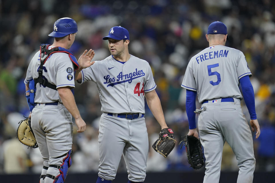 Los Angeles Dodgers relief pitcher Tommy Kahnle, center, celebrates with catcher Will Smith, left, and first baseman Freddie Freeman after the Dodgers defeated the San Diego Padres 1-0 in 10 innings in a baseball game Wednesday, Sept. 28, 2022, in San Diego. (AP Photo/Gregory Bull)