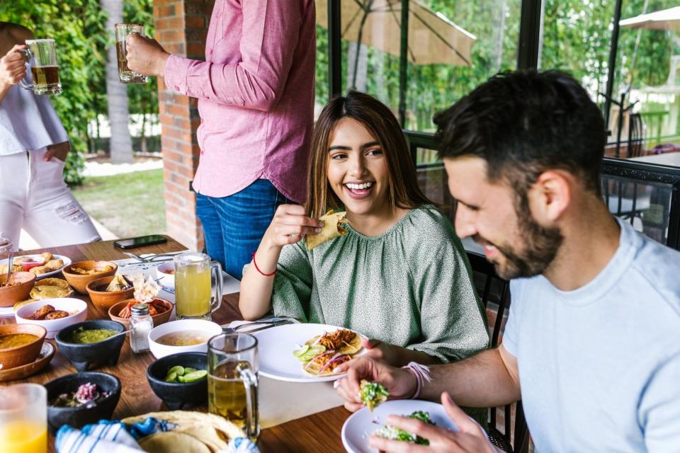 A couple eating tacos together.