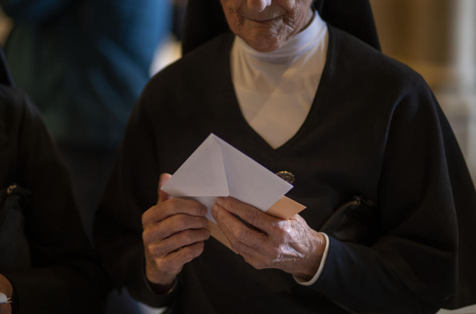 A nun holds her ballot paper before casting it for the general election in Barcelona, Spain, Sunday, Nov.10, 2019. Spain holds its second national election this year after Socialist leader Pedro Sanchez failed to win support for his government in a fractured Parliament. (AP Photo/Emilio Morenatti)