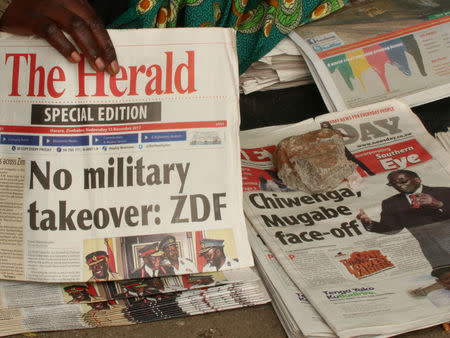 A vendor picks up a copy of a special edition of the state-owned daily newspaper The Herald in Harare, Zimbabwe November 15, 2017. REUTERS/Philimon Bulawayo