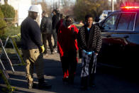 Neighbors and residents of Hogarth Avenue watch on as police, fire and other emergency personnel work at the scene Tuesday, Nov. 23, 2021 after a house fire and explosion in Flint, Mich. (Jake May/The Flint Journal via AP)