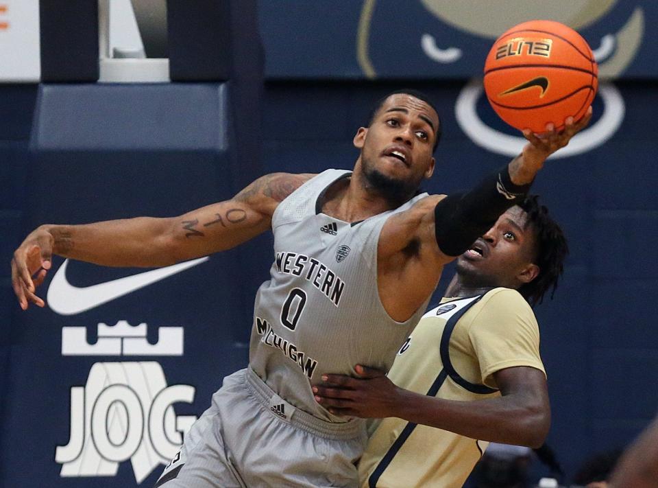 Western Michigan forward Markeese Hastings (0) tries to grab rebound over University of Akron forward Ali Ali (24) during the second half of Tuesday's game at Rhodes Arena. Ali made the game-winning shot in a 74-73 win for the Zips. [Jeff Lange/Beacon Journal]