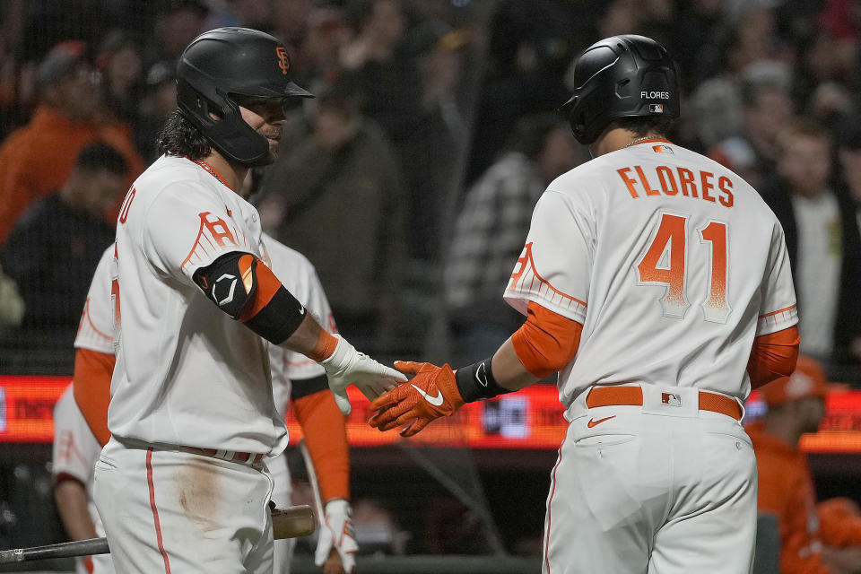 San Francisco Giants' Wilmer Flores (41) is congratulated by Brandon Crawford after hitting a solo home run against the Washington Nationals during the seventh inning of a baseball game Friday, July 9, 2021, in San Francisco. (AP Photo/Tony Avelar)