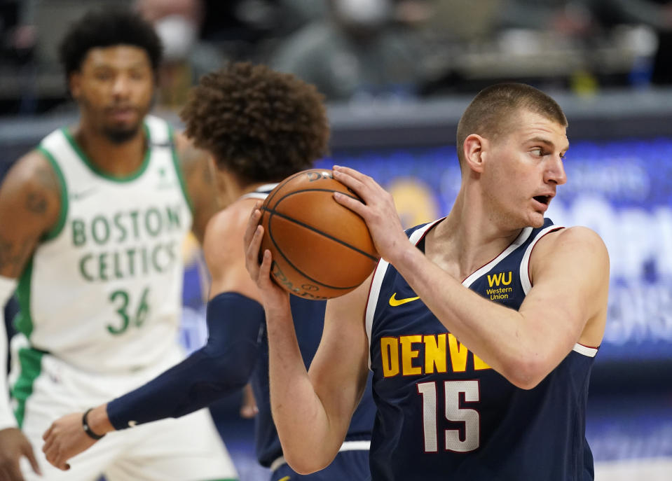 Denver Nuggets center Nikola Jokic, right, pulls in a rebound in the first half of an NBA basketball game Sunday, April 11, 2021, in Denver. (AP Photo/David Zalubowski)