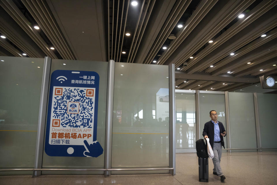 A traveler walks through the international flight arrivals area at Beijing Capital International Airport in Beijing, Wednesday, April 26, 2023. Travelers entering China will no longer need to provide a negative PCR test result starting from Saturday, in another easing of China's "zero-COVID" policies. (AP Photo/Mark Schiefelbein)