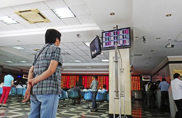 An investor looks at electronic screens showing stock information at a brokerage house in Nanjing, Jiangsu province, China, September 24, 2015. REUTERS/Stringer/Files
