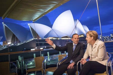 German Chancellor Angela Merkel (R) listens to Australian Prime Minister Tony Abbott aboard a boat in front of Sydney opera house in Sydney November 16, 2014. REUTERS/Guido Bergmann/Bundesregierung/Pool ATTENTION EDITORS - THIS PICTURE WAS PROVIDED BY A THIRD PARTY. FOR EDITORIAL USE ONLY. NOT FOR SALE FOR MARKETING OR ADVERTISING CAMPAIGNS. THIS PICTURE IS DISTRIBUTED EXACTLY AS RECEIVED BY REUTERS, AS A SERVICE TO CLIENTS. NO SALES. NO ARCHIVES