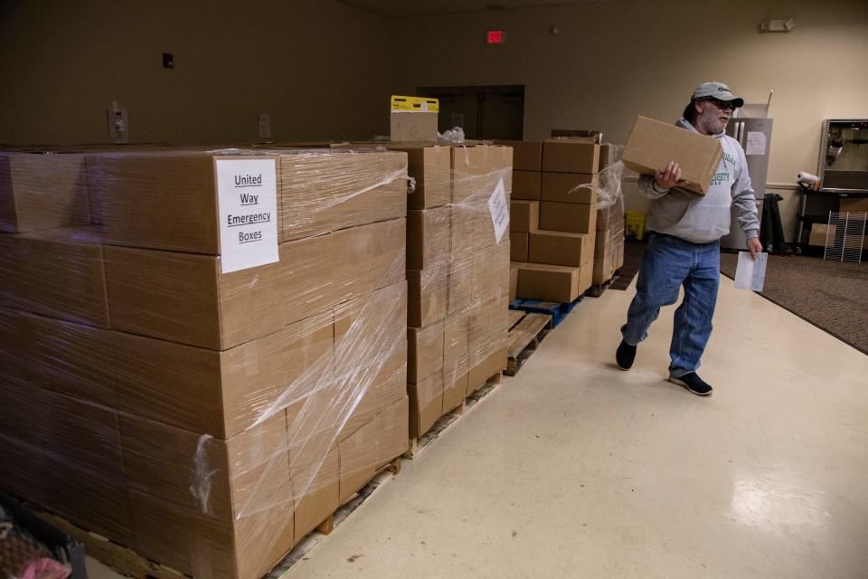 Steve Van Norman, 62, of Romulus and a 23 year GM employee, grabs a box of supplies to help out his family, Monday, Oct. 14, 2019, as Ford and Fiat Chrysler Automobiles workers are donating food and other items at the Local 163 in Westland, Mich.