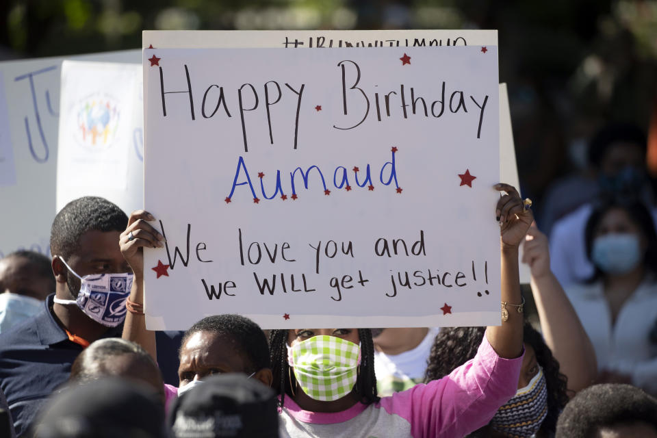 A woman holds a sign during a rally protesting the shooting of Ahmaud Arbery, an unarmed black man Friday, May 8, 2020, in Brunswick Ga. Two men have been charged with murder in the February shooting death of Arbery, whom they had pursued in a truck after spotting him running in their neighborhood. (AP Photo/John Bazemore)
