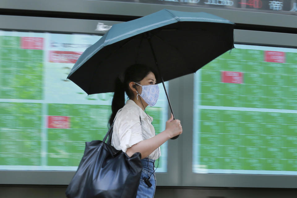 A woman walks by an electronic stock board of a securities firm in Tokyo, Wednesday, Sept. 15, 2021. Asian stock markets followed Wall Street down on Wednesday after U.S. inflation was lower than expected amid unease about the impact of the spread of the coronavirus's delta variant. (AP Photo/Koji Sasahara)
