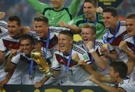 Germany's Bastian Schweinsteiger carries the World Cup trophy as he celebrates with teammates after the 2014 World Cup final between Germany and Argentina at the Maracana stadium in Rio de Janeiro July 13, 2014. REUTERS/Kai Pfaffenbach (BRAZIL - Tags: SPORT SOCCER WORLD CUP)