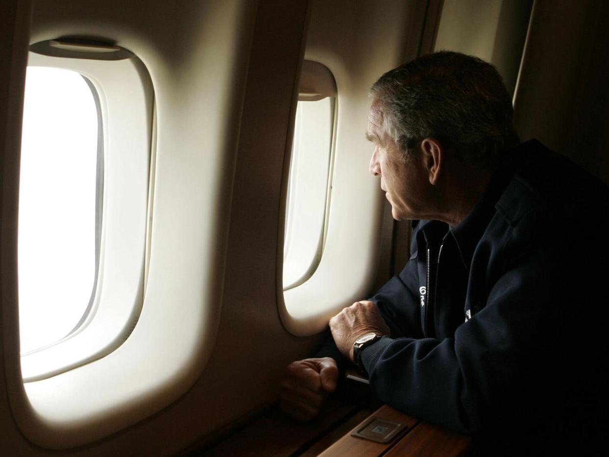 George W. Bush, as US President, looks out window of Air Force One to inspect damage from Hurricane Katrina while flying over New Orleans, photo