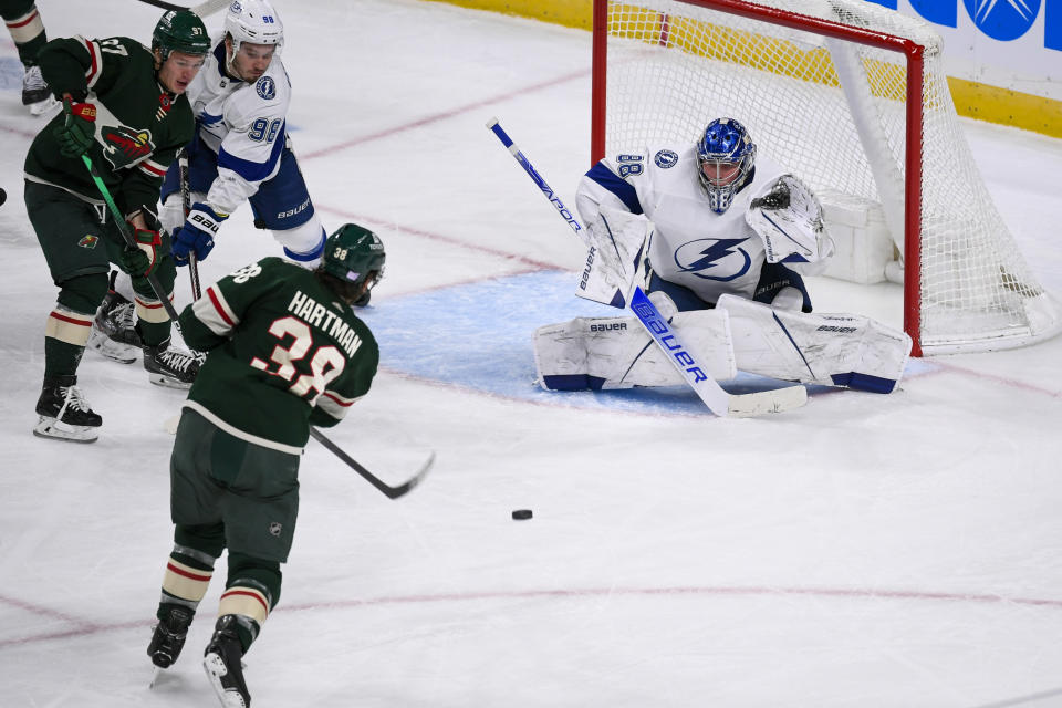 Minnesota Wild right wing Ryan Hartman (38) scores the go-ahead goal past Tampa Bay Lightning goalie Andrei Vasilevskiy as Wild left wing Kirill Kaprizov, left, and Lightning defenseman Mikhail Sergachev look on during the third period of an NHL hockey game Sunday, Nov. 28, 2021, in St. Paul, Minn. (AP Photo/Craig Lassig)