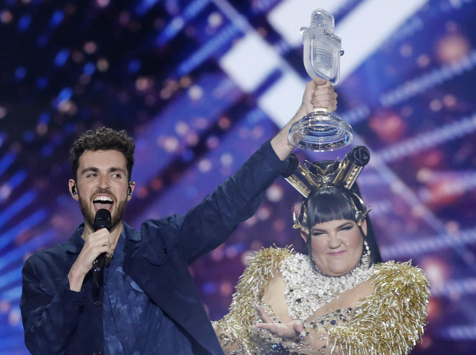 Duncan Laurence of the Netherlands celebrates with the trophy after winning the 2019 Eurovision Song Contest grand final with the song "Arcade" in Tel Aviv, Israel, Saturday, May 18, 2019. In rear is Israeli Netta Barzilai the winner in 2018. (AP Photo/Sebastian Scheiner)