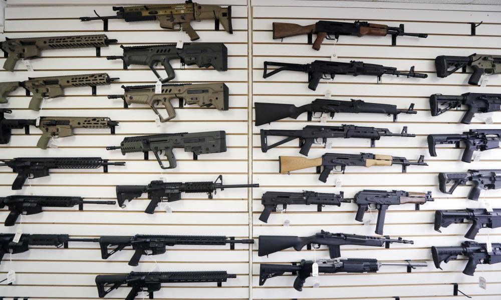 Semi-automatic rifles fill a wall at a gun shop in Lynnwood, Washington, in 2018. As of 1 January, no one under the age of 21 in Washington can purchase a such weapons.