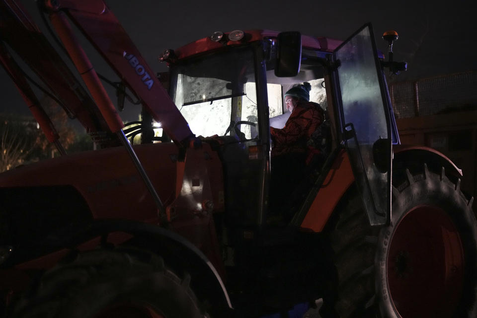 A farmer spends the night at a highway barricade in Aix-en-Provence, southern France, Tuesday, Jan. 30, 2024. France's protesting farmers encircled Paris with traffic-snarling barricades Monday, using hundreds of lumbering tractors and mounds of hay bales to block highways leading to France's capital to pressure the government over the future of their industry. (AP Photo/Daniel Cole)