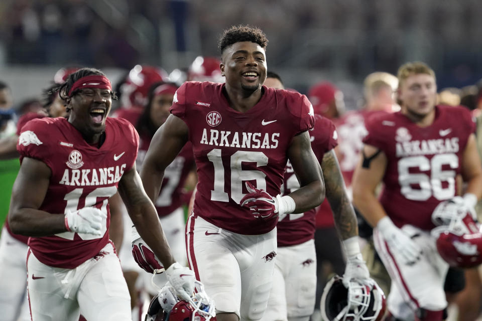 Arkansas wide receiver Treylon Burks (16) and teammates celebrate after their win in an NCAA college football game against Texas A&M in Arlington, Texas, Saturday, Sept. 25, 2021. (AP Photo/Tony Gutierrez)