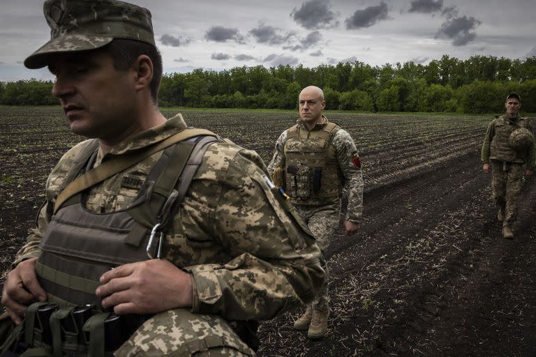 Roman Kachur (centro) comandante de la 55ª Brigada de Artillería Separada de Ucrania, camina hacia una posición de tiro en la región de Donetsk