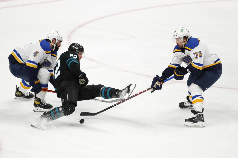 St. Louis Blues defenseman Nick Leddy, left, and defenseman Justin Faulk, right, compete for the puck against San Jose Sharks left wing Rudolfs Balcers (92) during the second period of an NHL hockey game in San Jose, Calif., Thursday, April 21, 2022. (AP Photo/Josie Lepe)